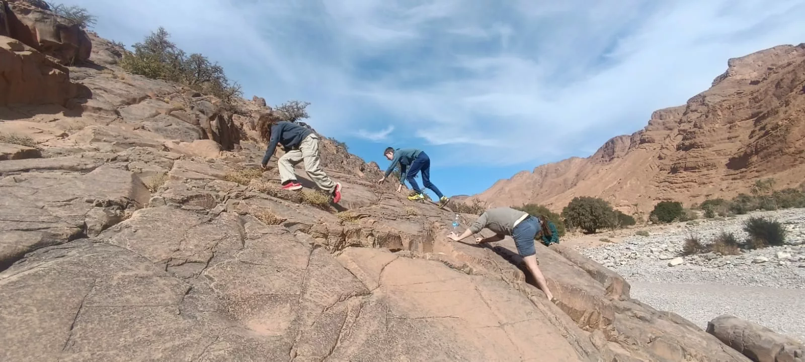 Teenagers and parents climbing Morocco river bed
