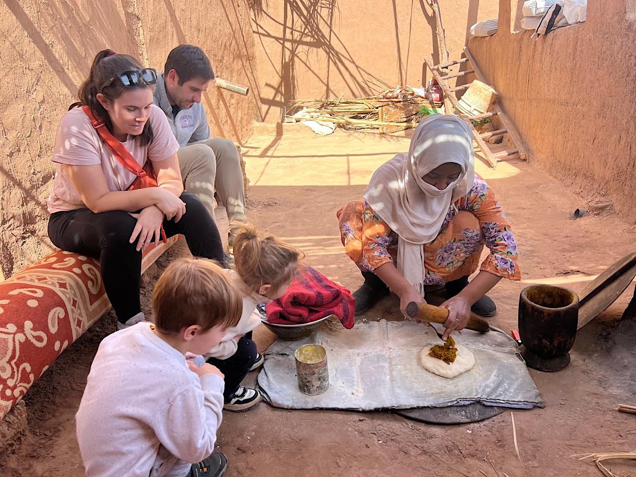 Morocco with children tour scene baking pie with village ladies 