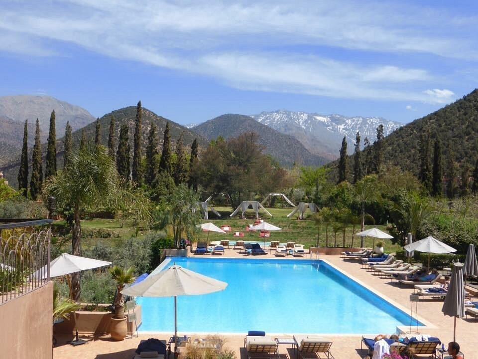 Luxury resort in the Moroccan Atlas Mountains with a pool, loungers, and scenic mountain views — one of the best resorts in Morocco