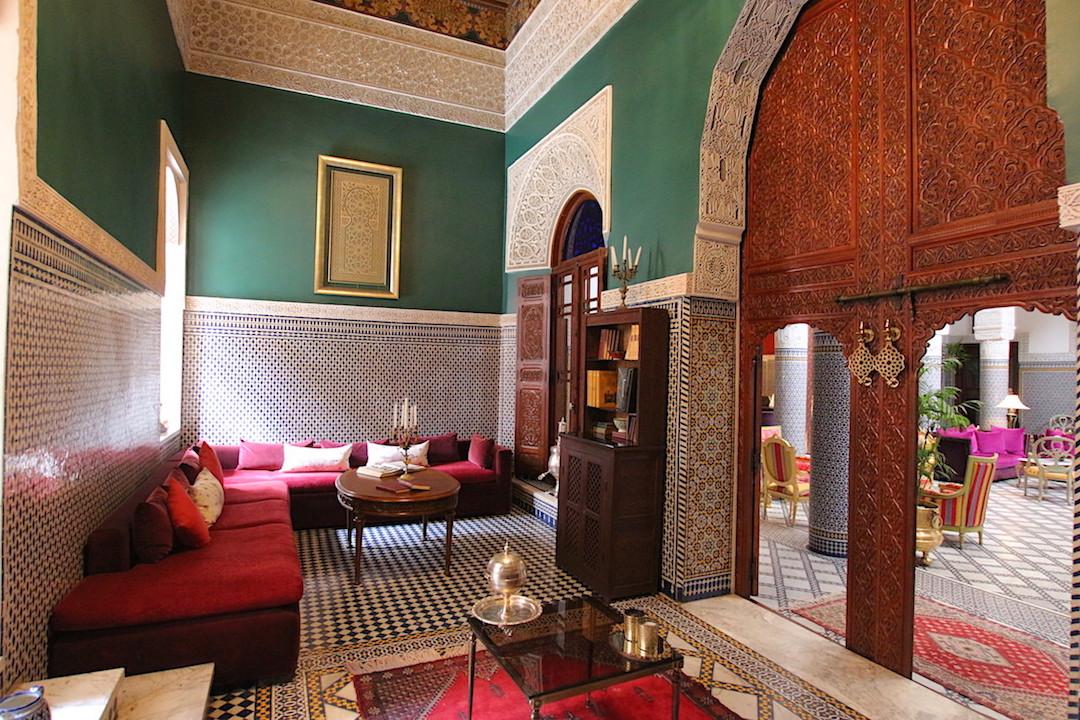 Traditional Moroccan lounge with colorful zellige tiles, carved wood arches, and elegant decor at one of the best resorts in Morocco.