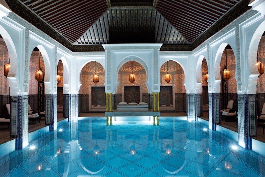 Luxurious Moroccan riad featuring a stunning indoor pool with traditional archways and intricate tile work, showcasing the authentic and high-end experiences provided by the best Morocco tour companies for travelers seeking cultural immersion and comfort