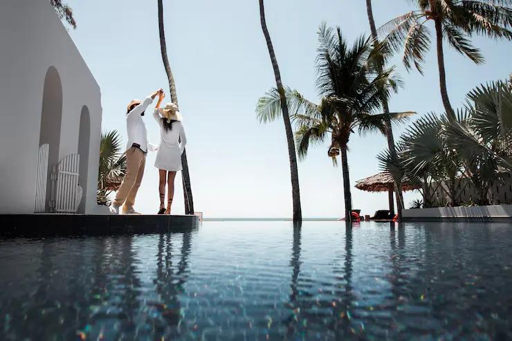 Infinity pool with stunning ocean views framed by tropical palm trees and modern resort architecture, highlighting the romantic poolside experiences and premium facilities available at all inclusive resorts in Morocco