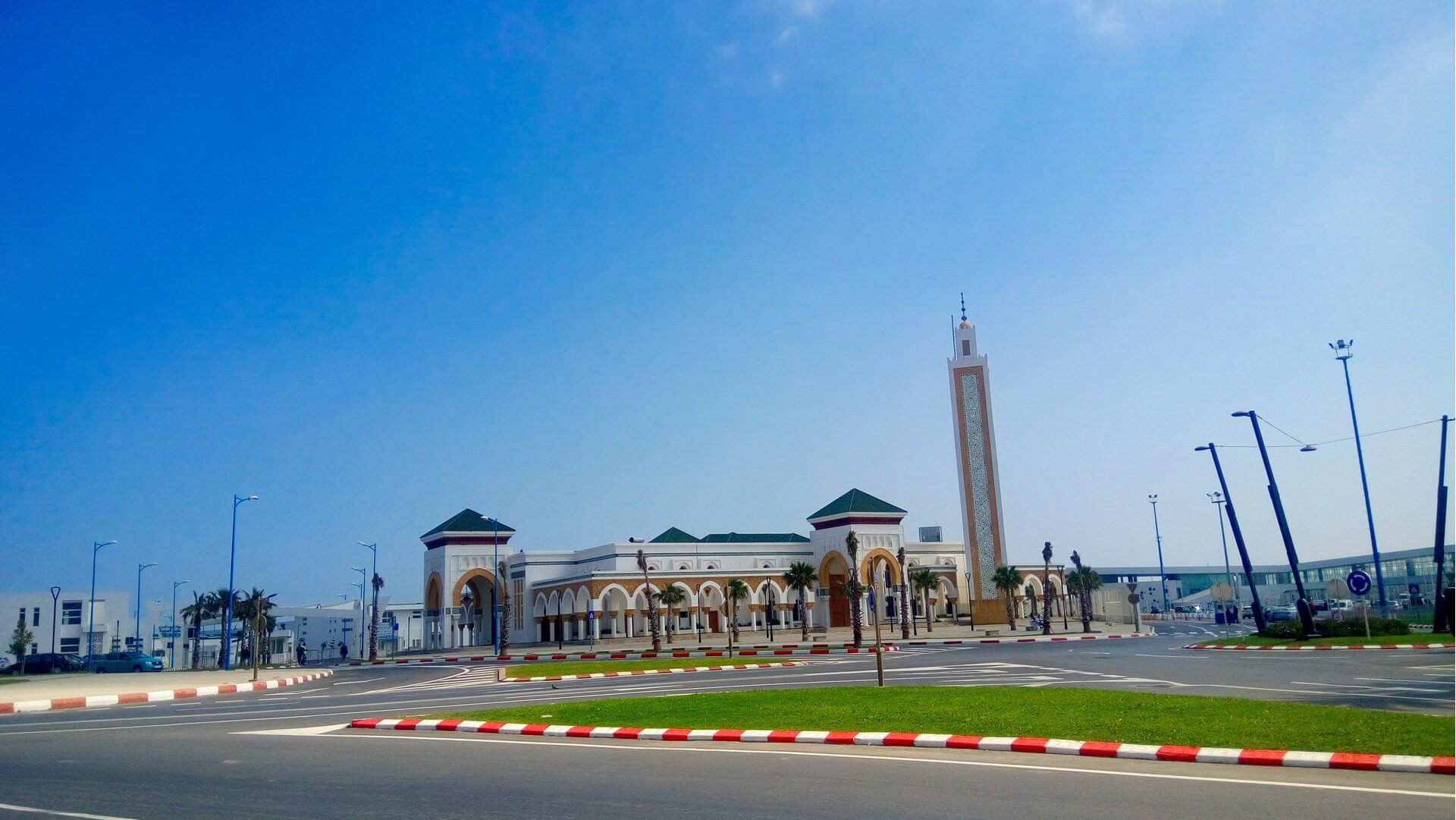 Visit Morocco: A Luxury Journey Through Imperial Cities, Atlas Peaks and Sahara Dunes 7 Modern Moroccan-style building with a tall minaret under a clear blue sky, reflecting the country's blend of tradition and modernity