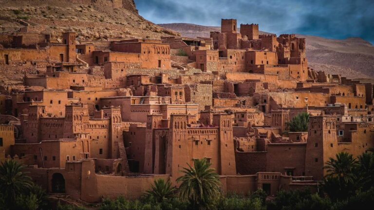 Historic mud-brick kasbah of Aït Benhaddou rising against desert mountains in Morocco, a UNESCO World Heritage Site safe to visit for tourists